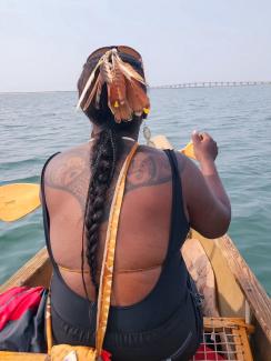 Chenae Bullock paddling in the bow of the Canoe in the Shinnecock Bay. Photo by Sierra Gumbs